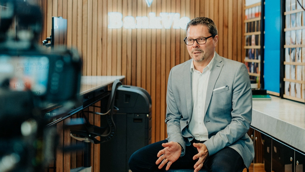 Photo of Scott Wall, Former Chief Information Officer of Bank VIC in front of a video camera for our customer story shoot.