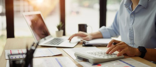 A close-up image of a business professional reviewing financial data at a modern office desk