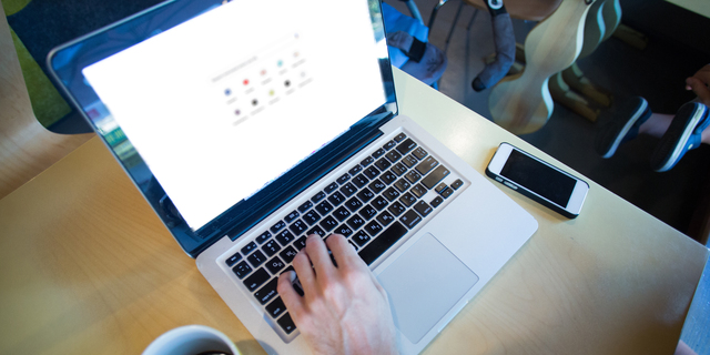 cropped view of man using laptop with google website on screen