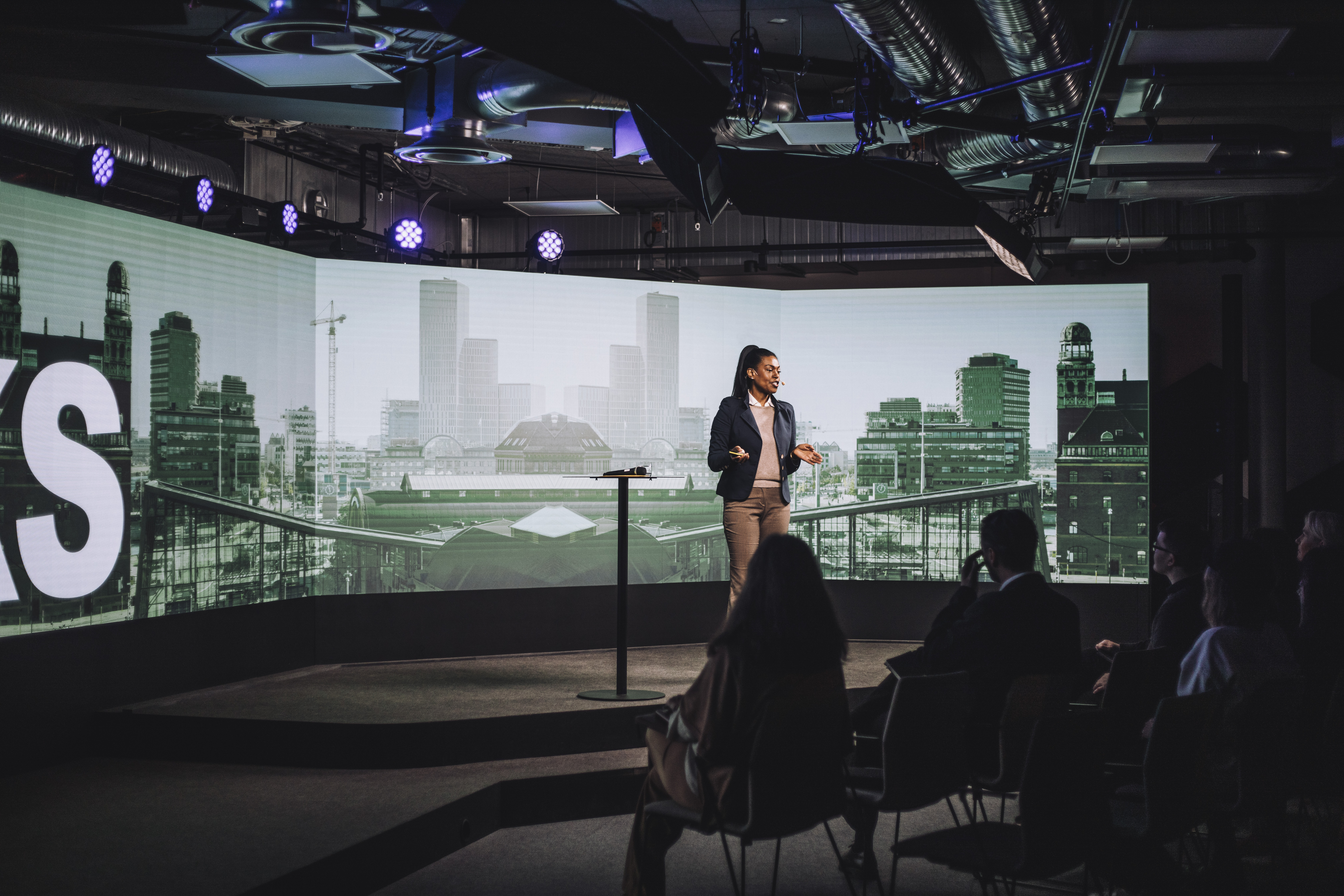 A woman gives a presentation with the use of immersive 4K AV technology