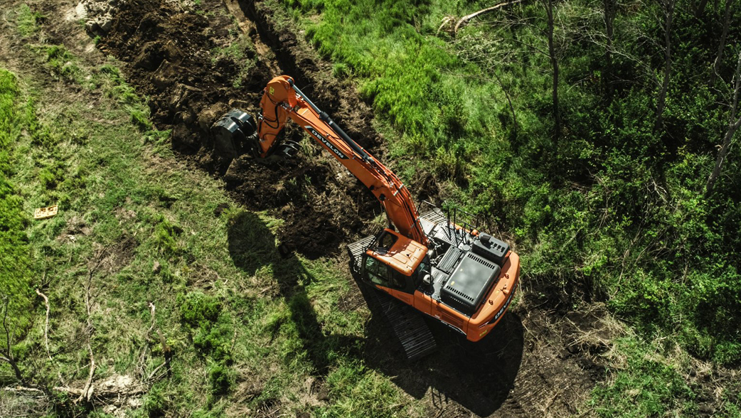 An overhead shot of a DEVELON crawler excavator working in a field.