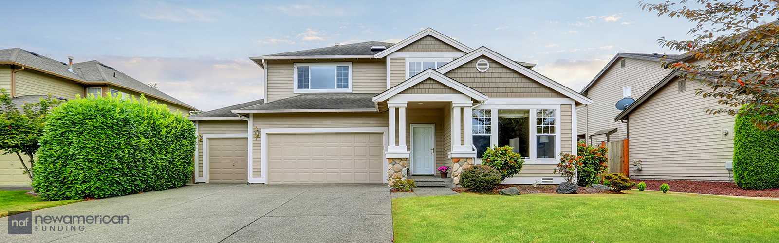 A nice beige house in a neighborhood sitting on a well-maintained small green lawn