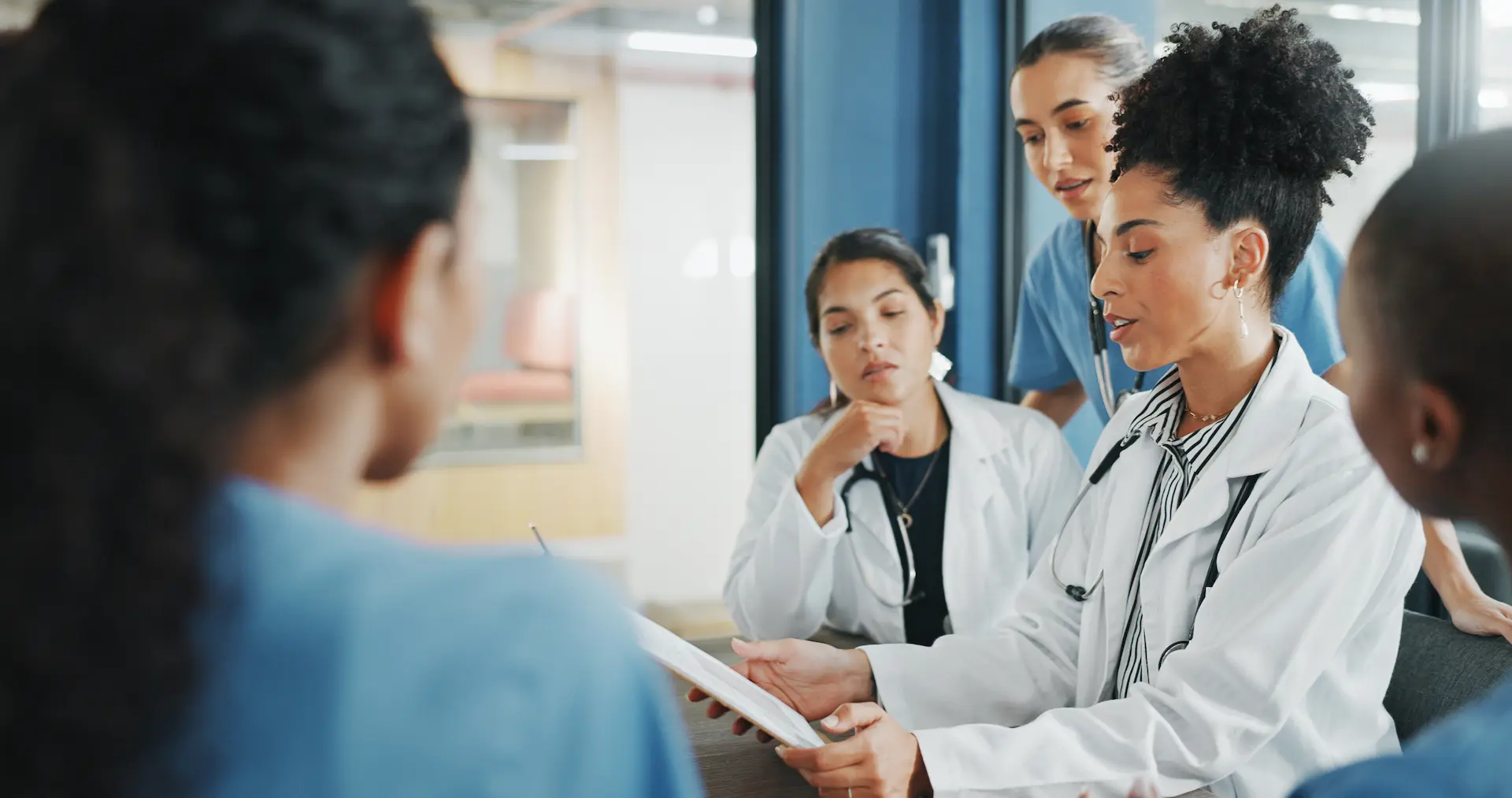 Clinicians reviewing patient information in a multidisciplinary meeting.