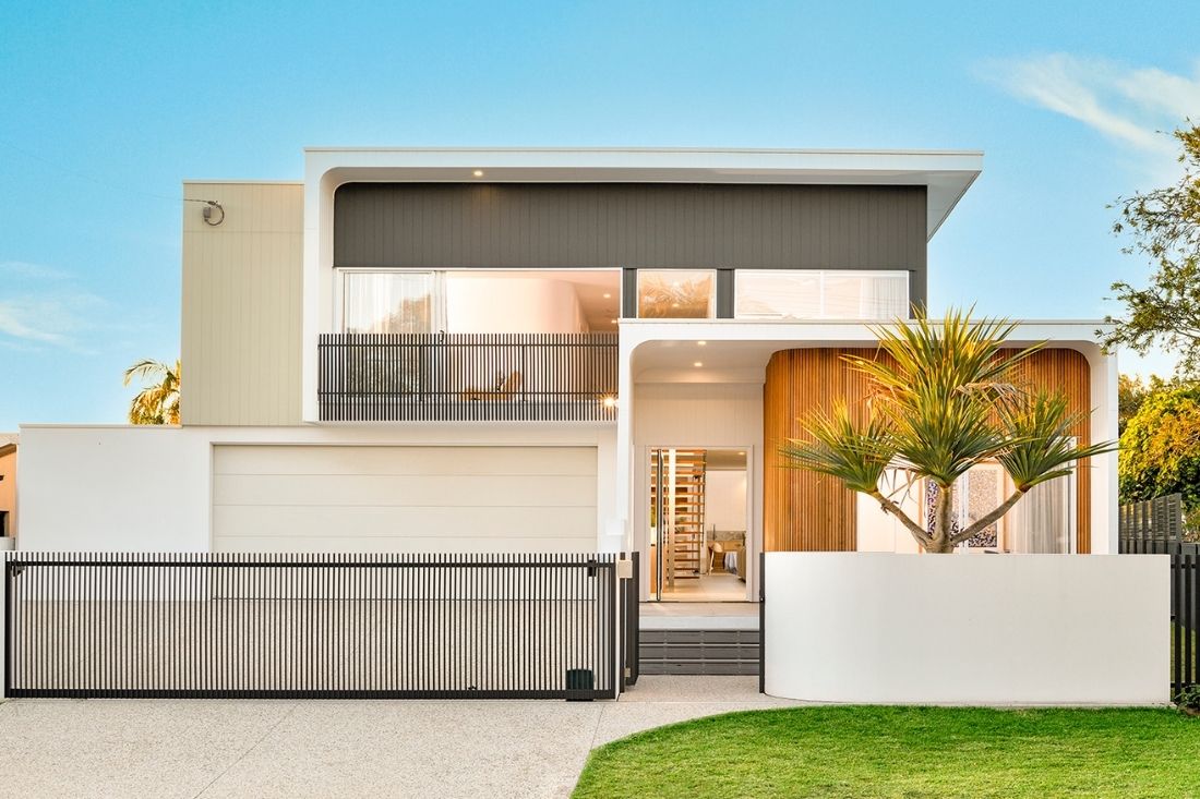 Two level home with driveway and gardens