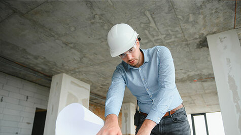 Engineer reviewing blueprints on a construction site