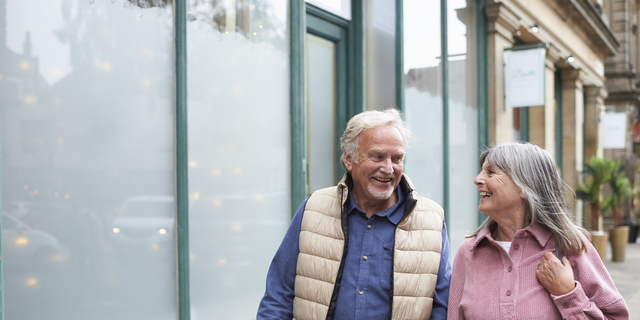 Happy senior couple walking on a city street