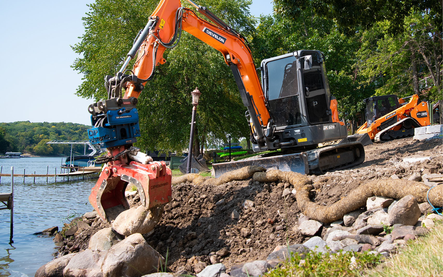 A DEVELON DX62R-7 mini excavator with a grapple attachment.