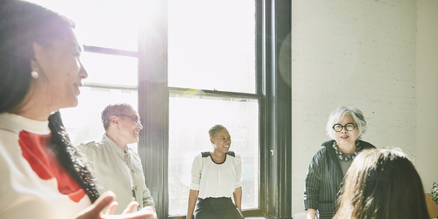 Senior businesswoman leading team meeting with colleagues in office