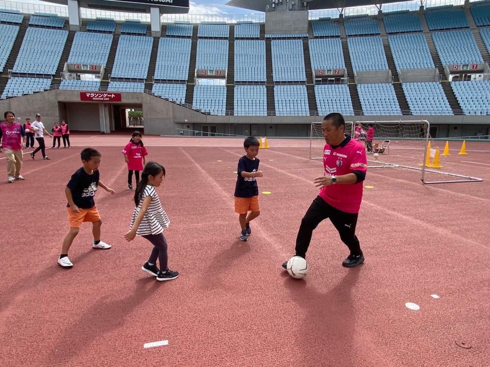 Cerezo president Morisima plays football with children