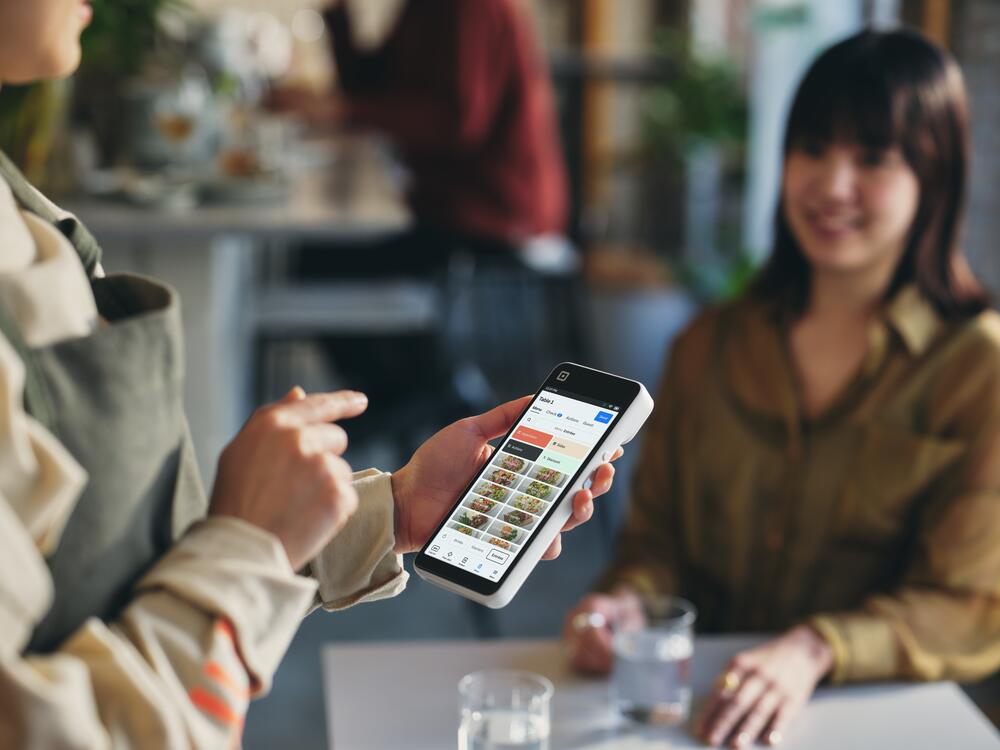 Restaurant operator using Square Handheld to take orders
