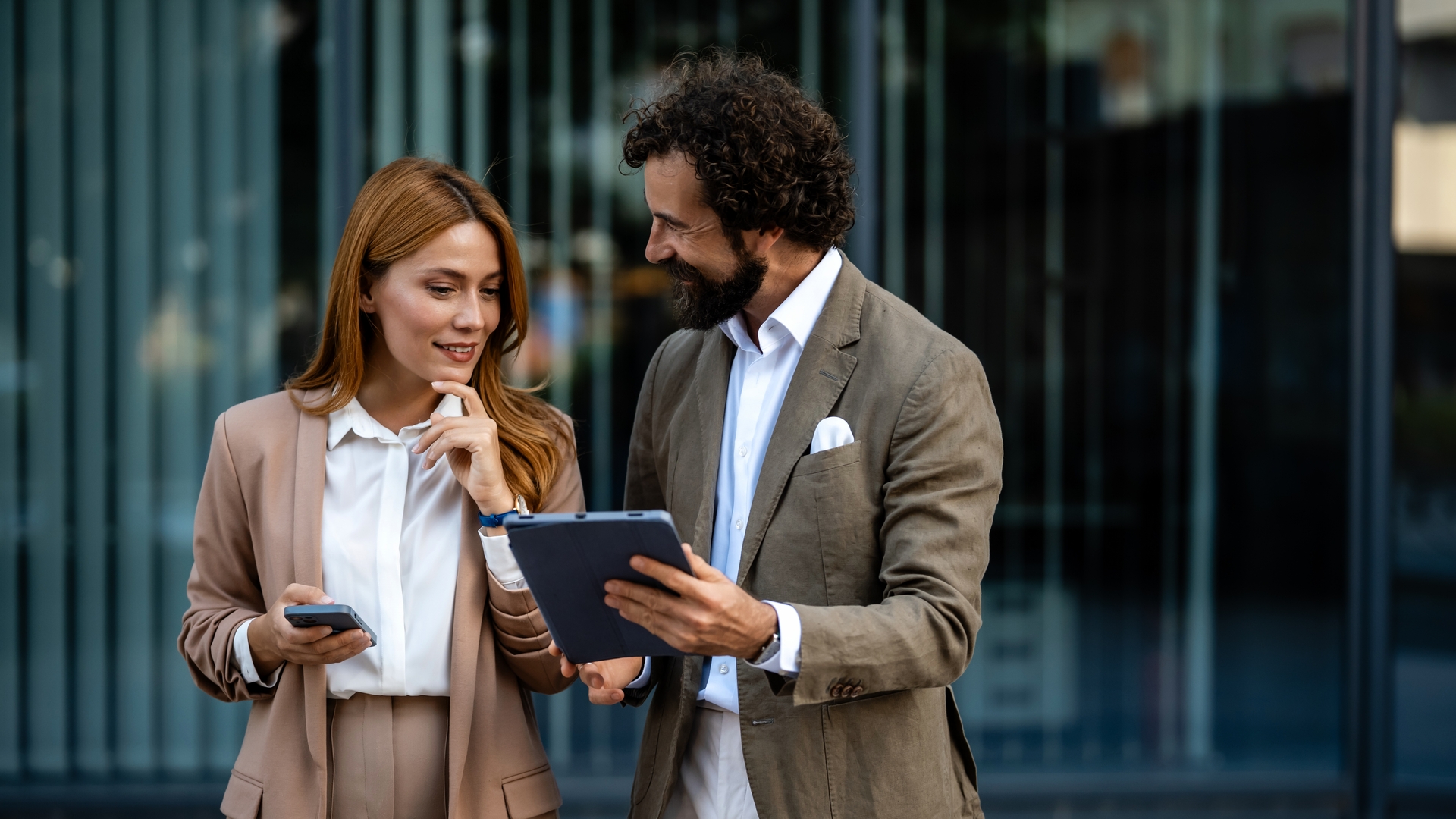 Business people using digital tablet and smartphone outdoors