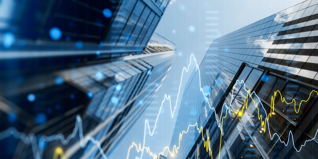 A double exposure image of skyscrapers with overlay of financial graphs, set against a blurred background, illustrating the concept of business growth