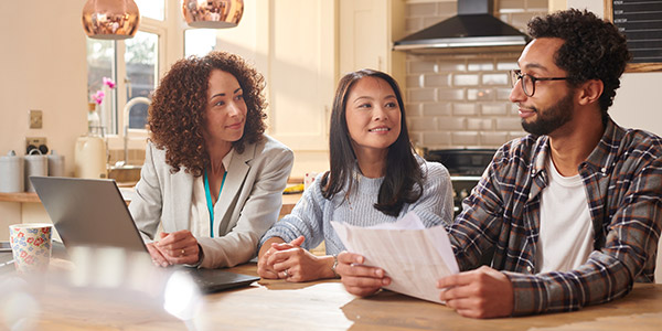 agent going over paperwork with clients over the kitchen table