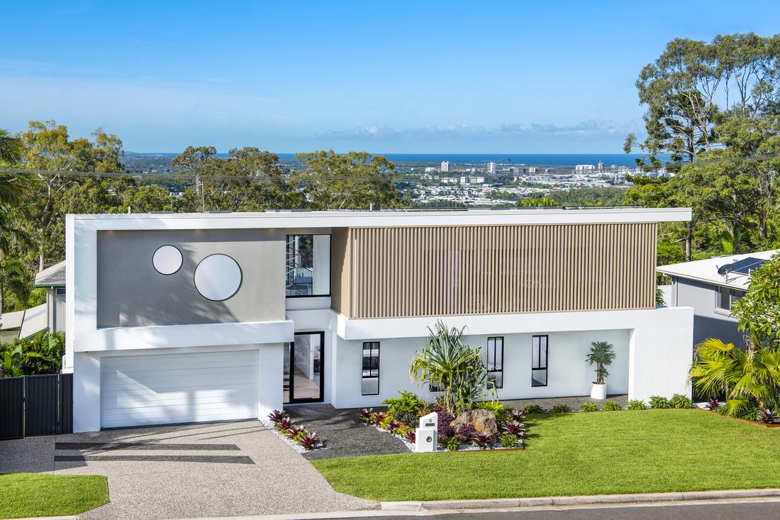 External shot of a two story house with a garage and garden.