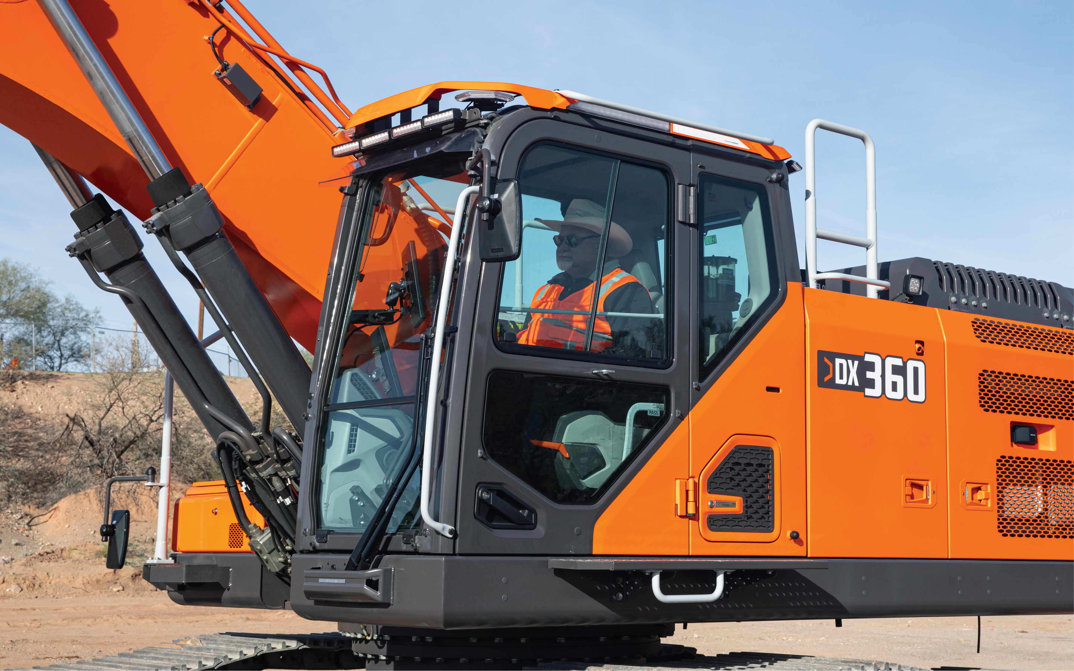 The operator cab of a DEVELON DX360LC-7 excavator featuring various visibility and operator comfort features.