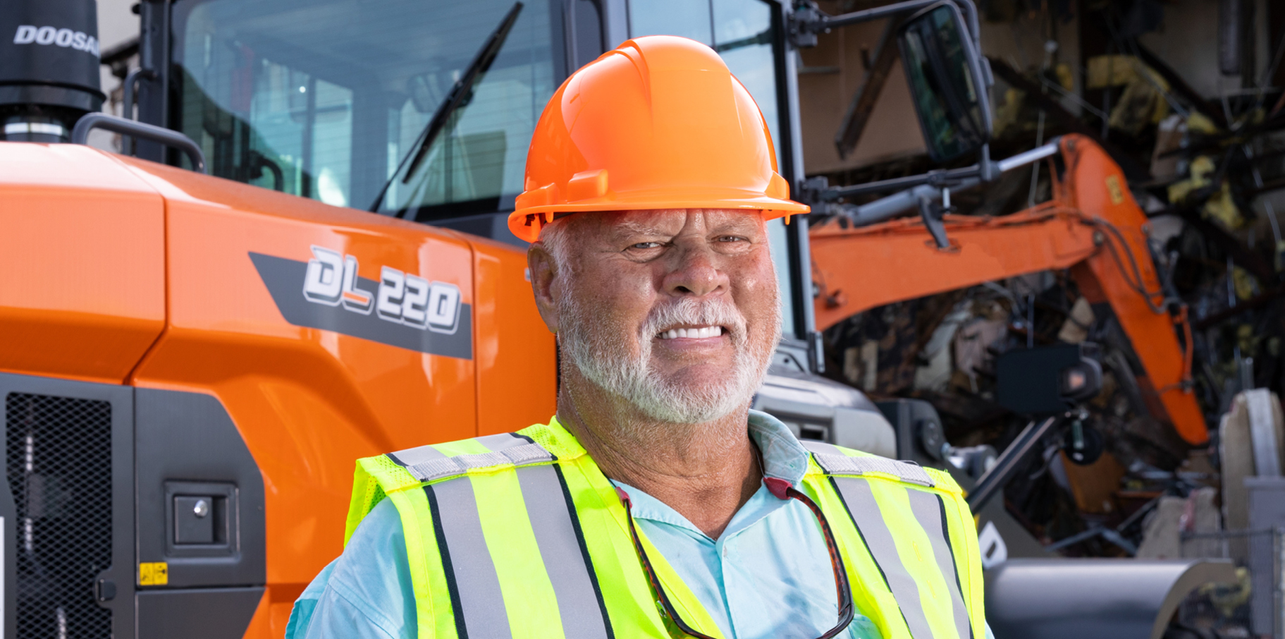 Tommy Britt of Britt Demolition and Recycling standing in front of his DEVELON machine.