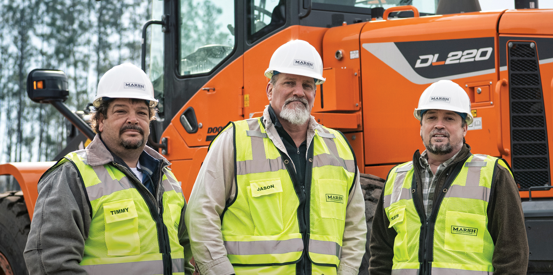 Timmy Marsh, Jason Dunn and Travis Marsh of Marsh Construction Services standing in front of their DEVELON equipment.