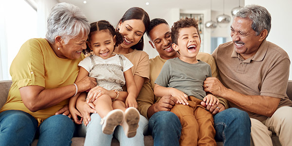 multi-generational family sitting on the living room couch together