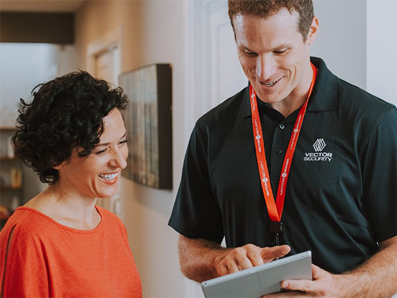 A Vector Security technician is working with a customer.
