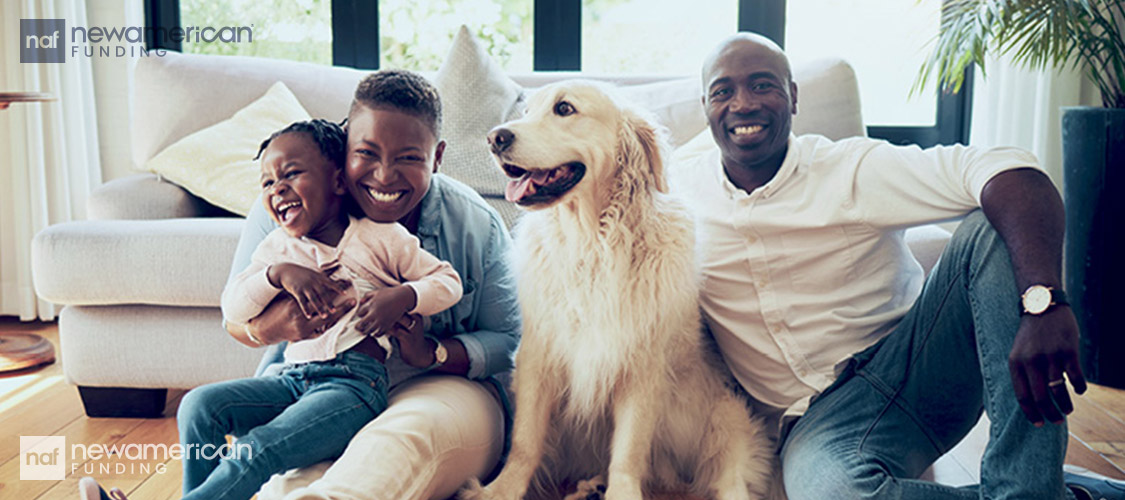 Happy Black family sitting in their home with a golden retriever