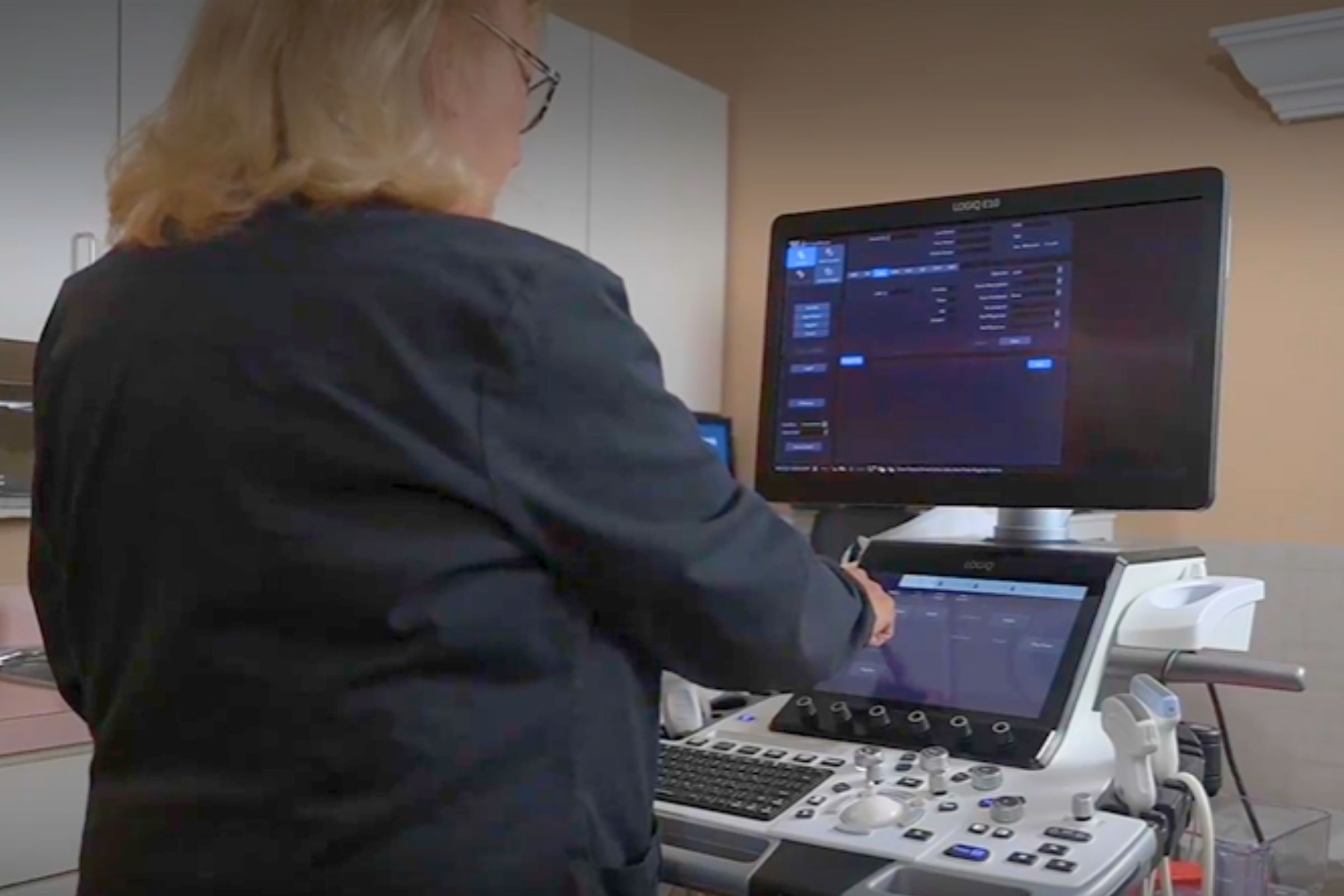 Sonographer reviews ultrasound protocols on a ultrasound system
