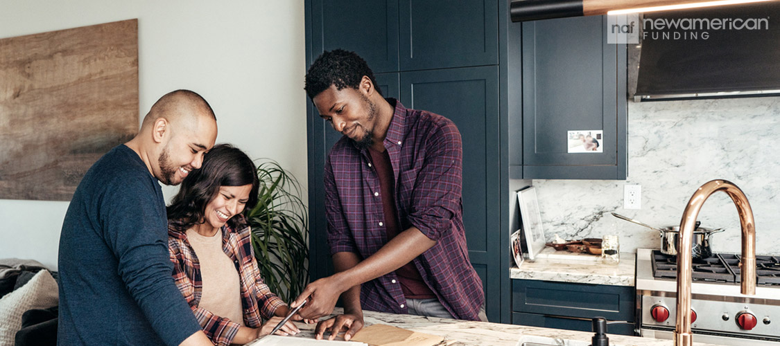 A Loan Officer goes over paperwork with a couple in their home