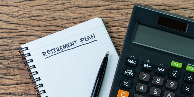 Retirement planning concept, calculator with empty notepad with pen and handwriting underline headline as Retirement Plan on wood table, plan of saving and investment for expense after retire life