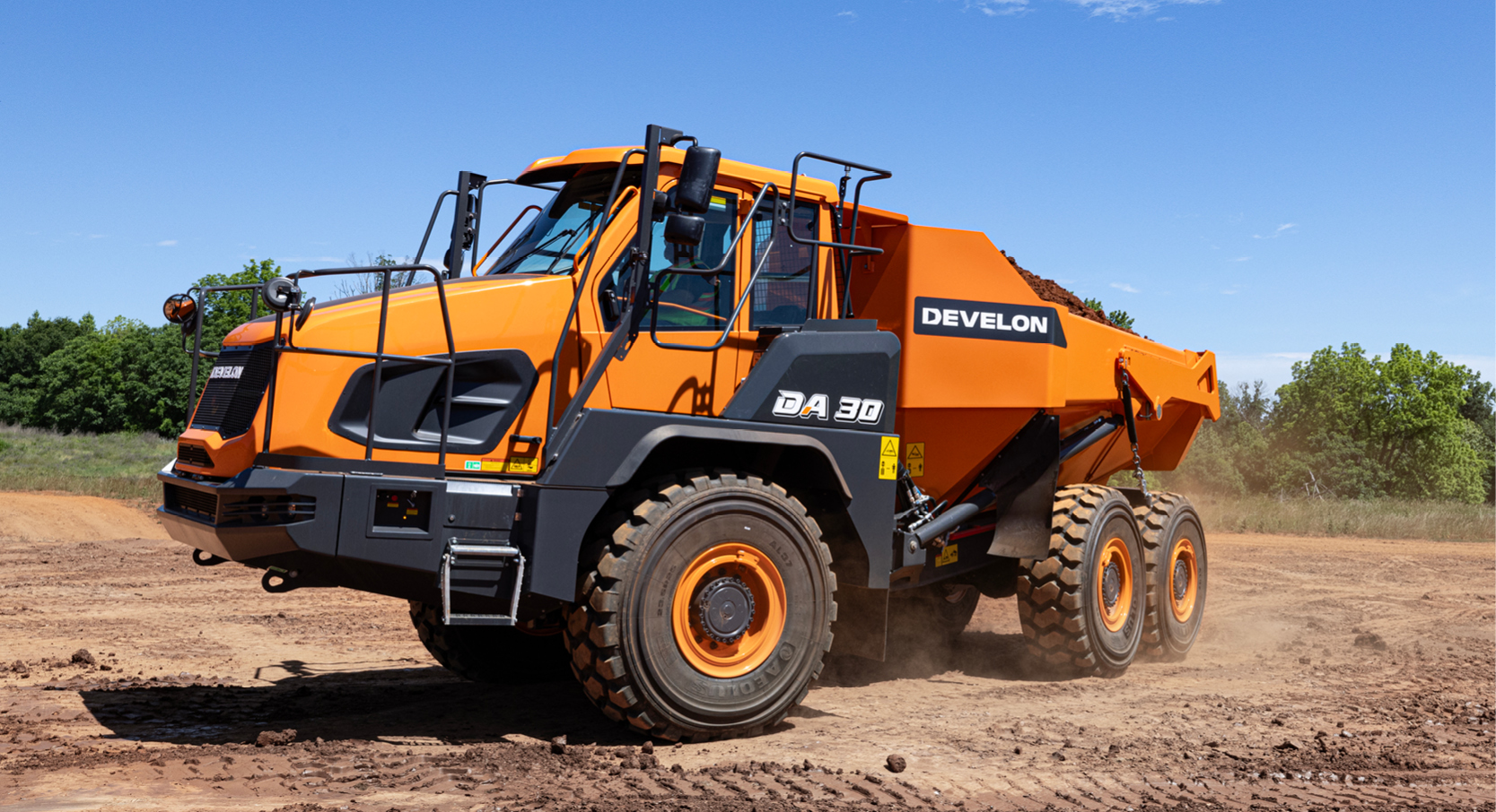 A DEVELON Articulated Dump Truck turning a corner carrying a large load of dirt.