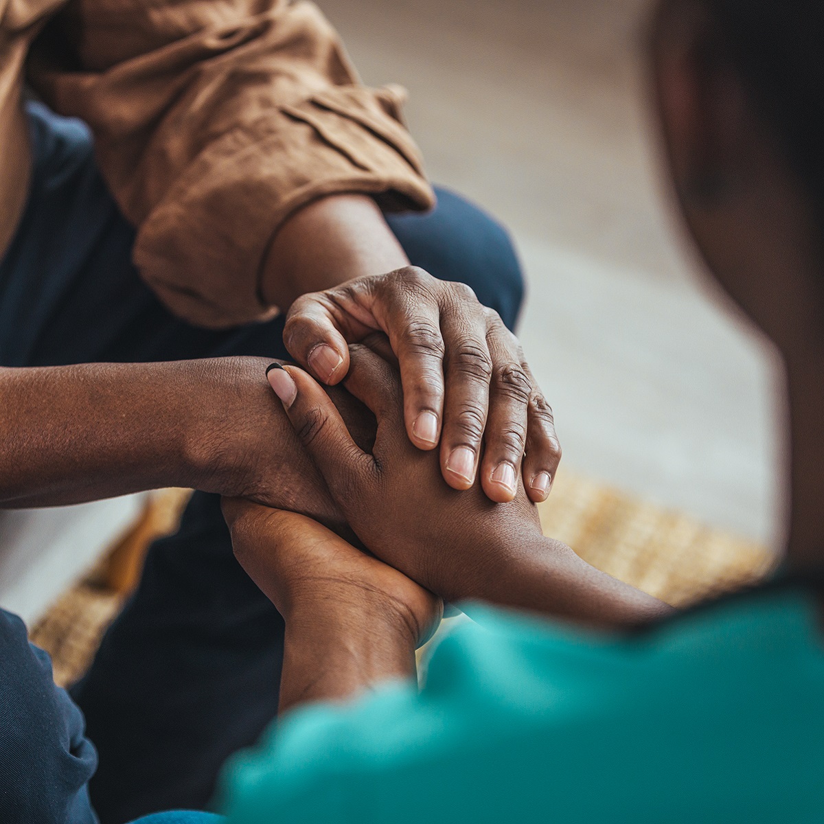 Closeup shot of a young woman holding a senior man's hands in comfort