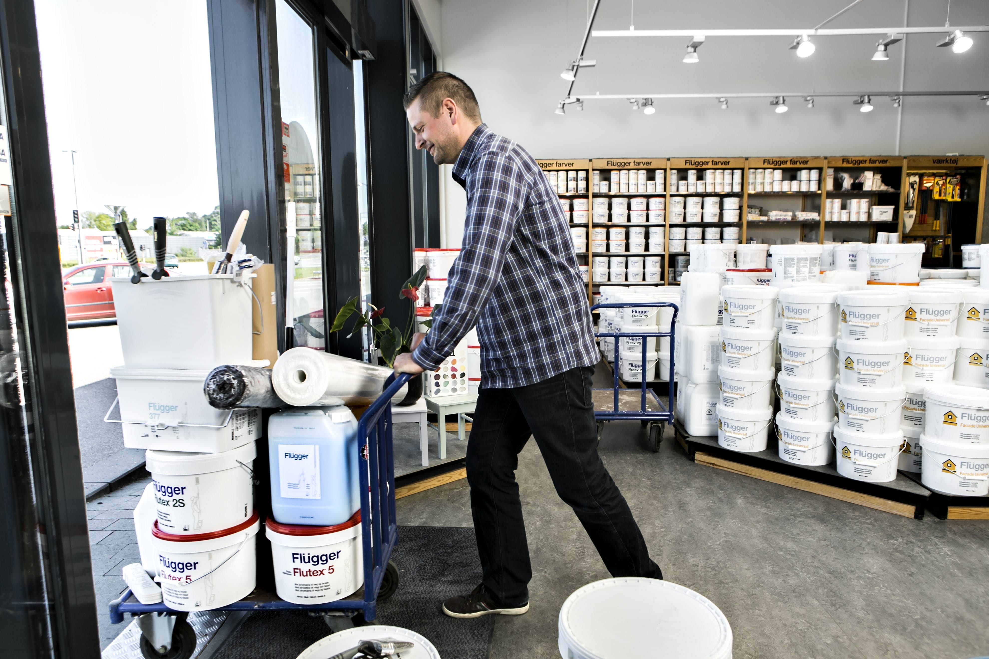 Man carrying paint out of a store