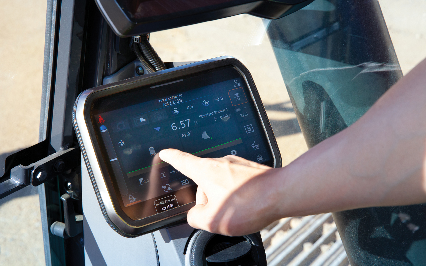 An operator in a DEVELON excavator cab presses the Smart Touch screen.