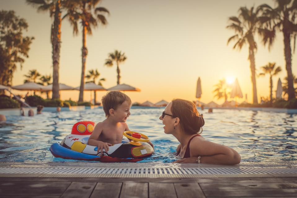 Child with mother in swimming pool, holiday resort