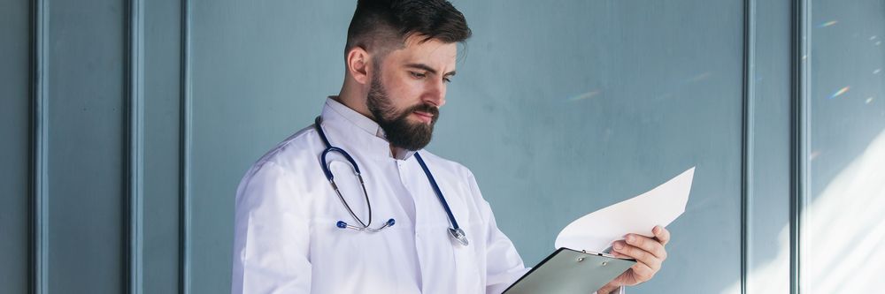 A doctor analyzes an ECG reading in a hospital to monitor cardiac complications of COVID-19.