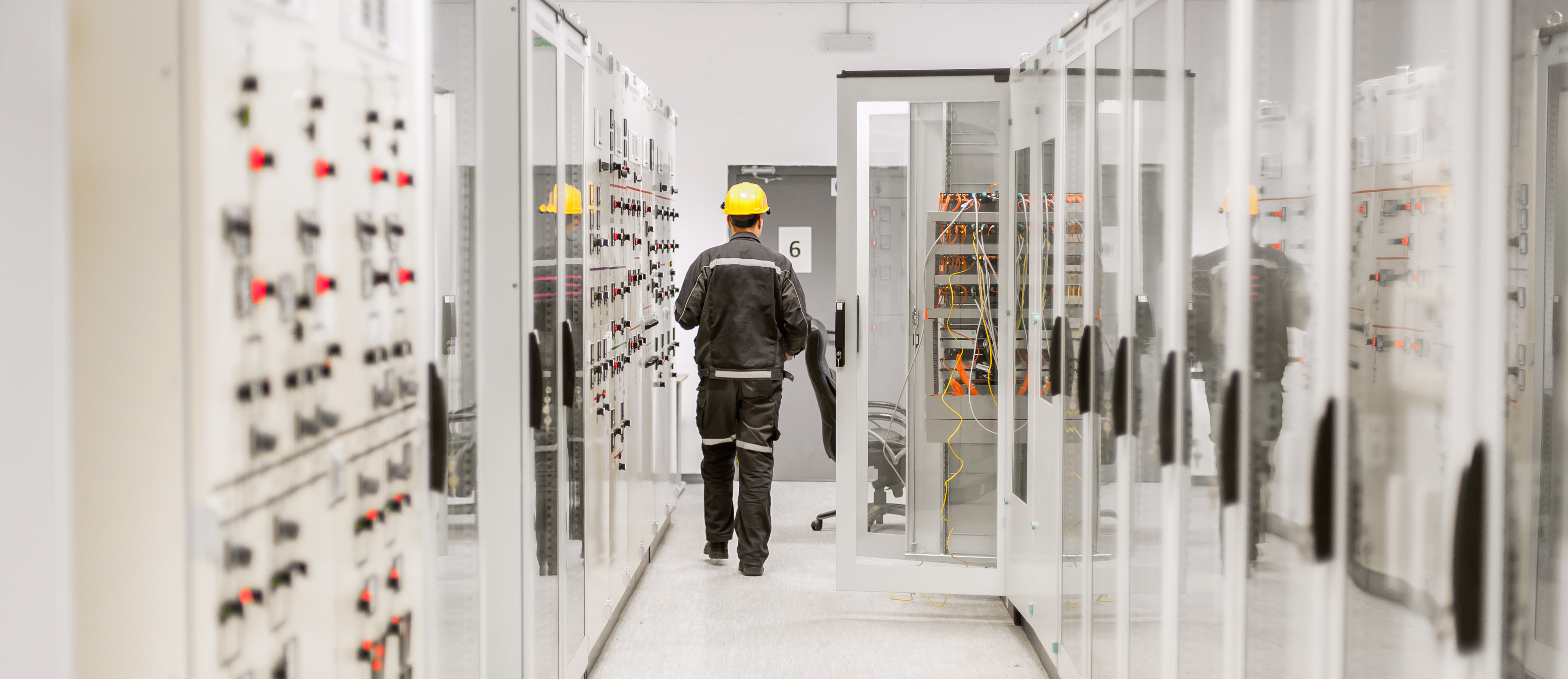 A man walking down a corridor with technology secured by utility cybersecurity.