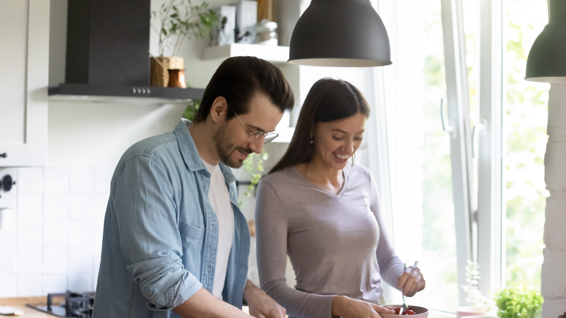 Happy millennial couple cook healthy salad in kitchen