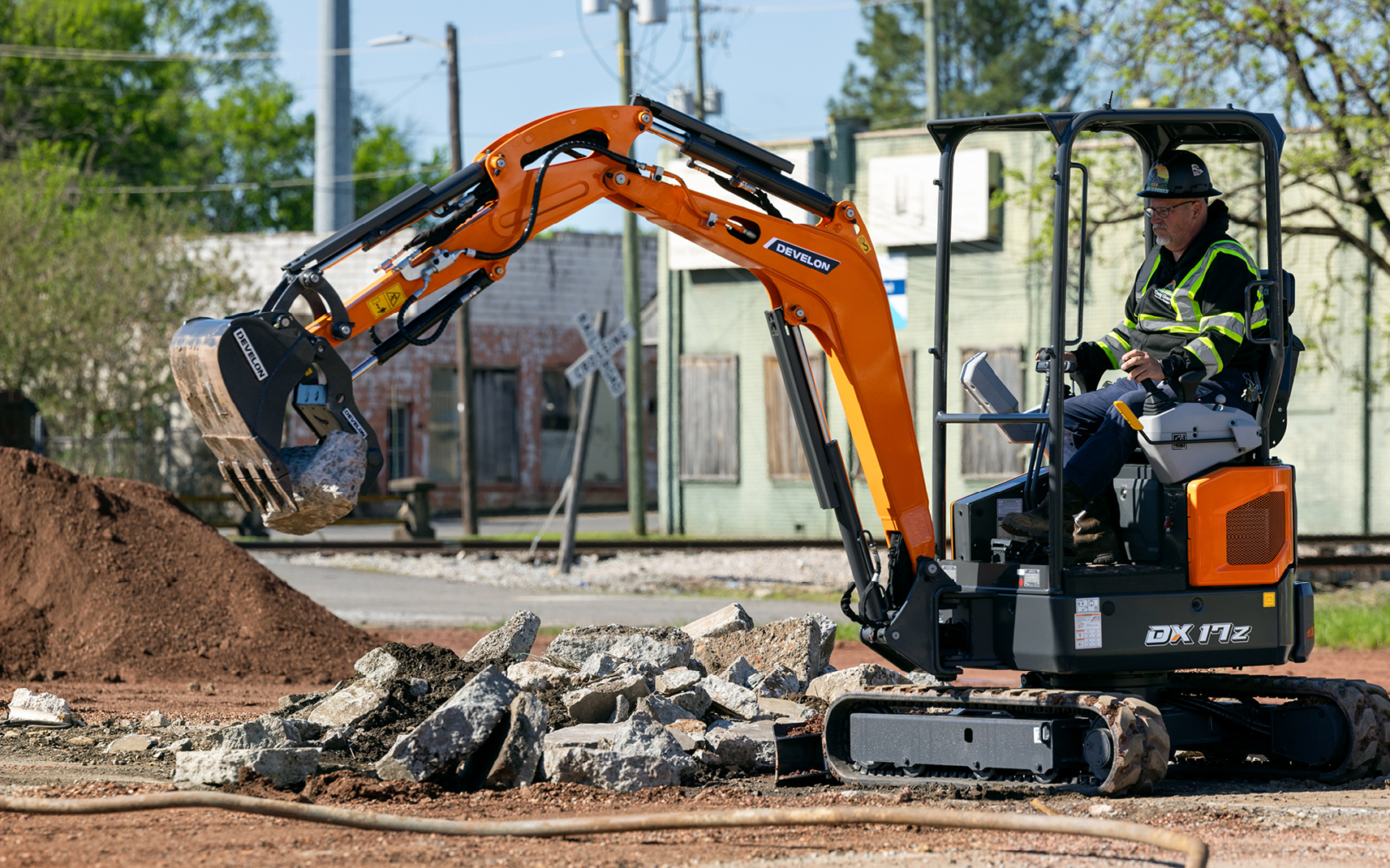 A DEVELON DX17Z-7 mini excavator moves debris on a construction site. 