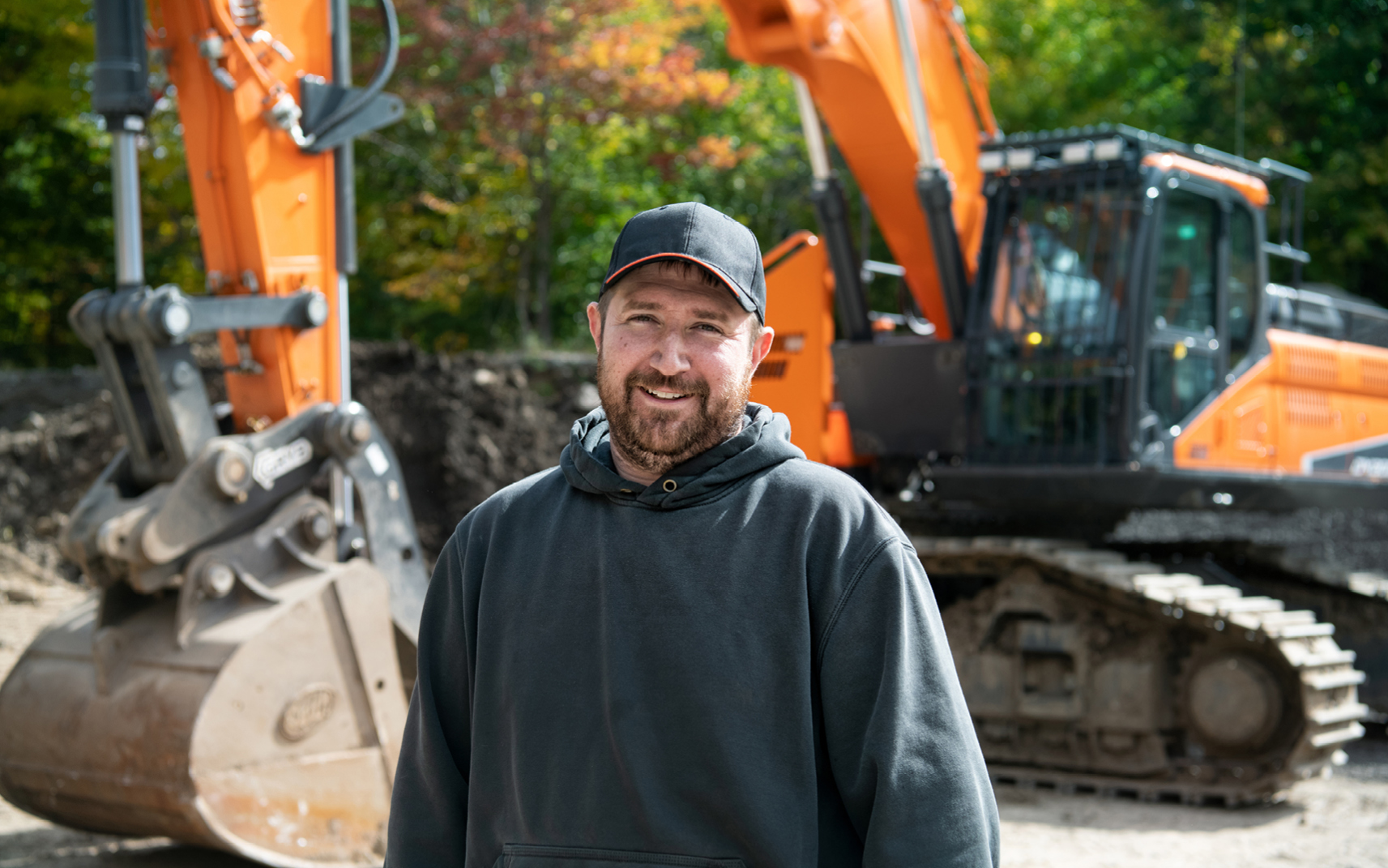 Josh Trudeau of Trudeau Construction next to his DEVELON crawler excavator.