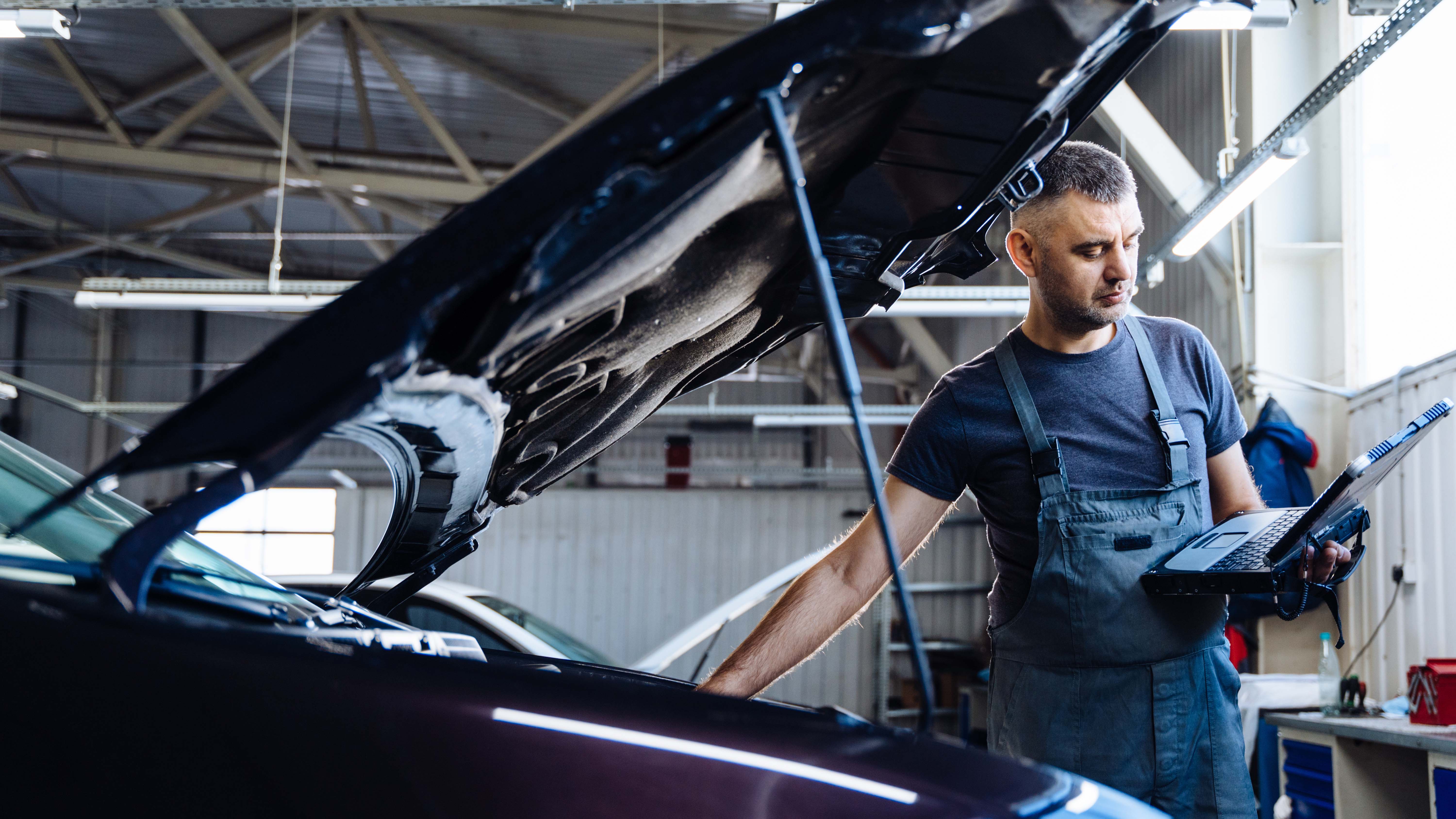 A mechanic servicing an electric car