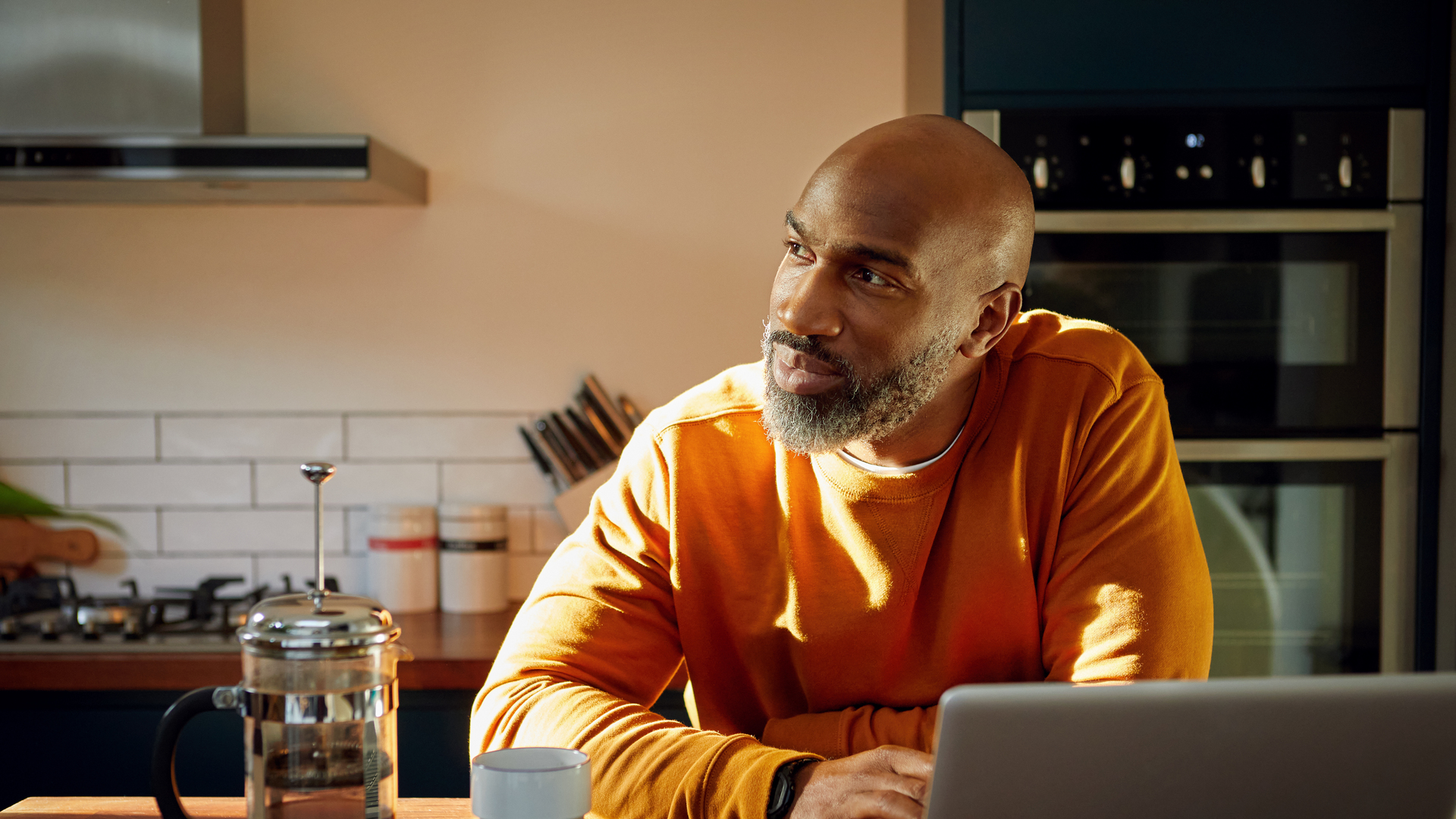 Mature man using laptop at kitchen island
