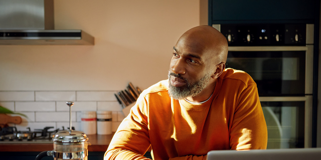 Mature man using laptop at kitchen island
