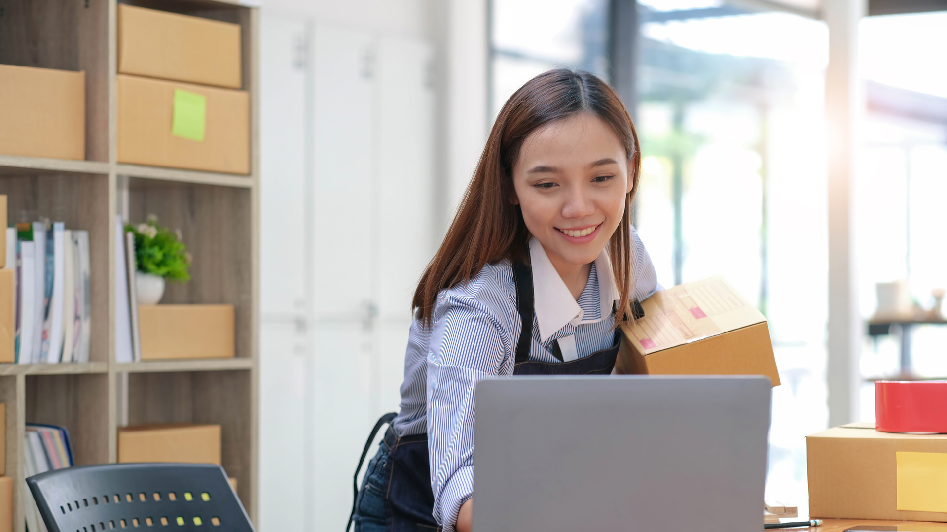 SME entrepreneur Business Young Asian freelance girl works with a laptop and box at home, about eCommerce, business, seller, Asian, employee, entrepreneur, box, merchant, Online SME business ideas,