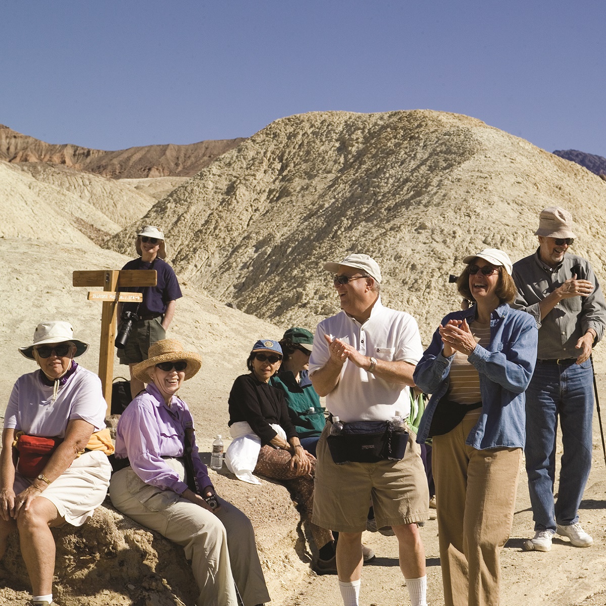 A group of Road Scholars laughing together in the desert outside of Death Valley National Park