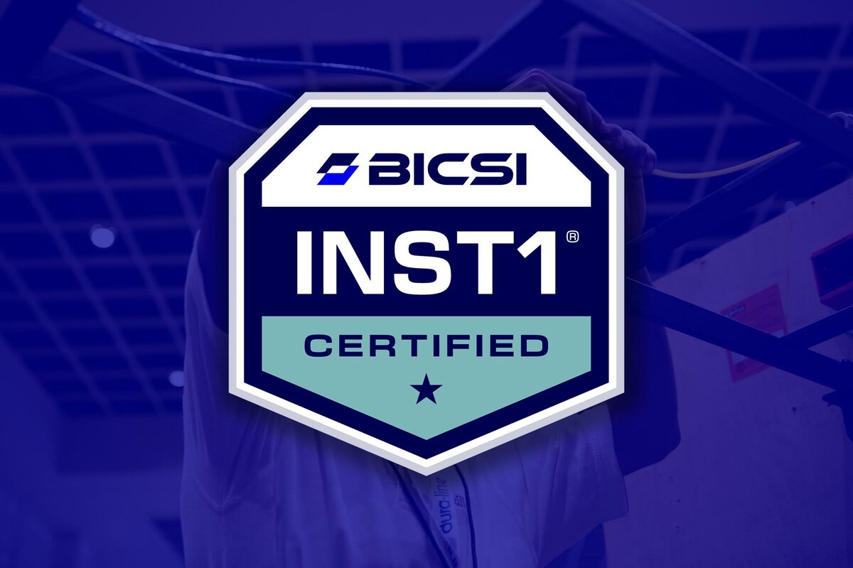 Installer 1 Certificate overlayed on blue background image of installer installing cables during the cabling skills challenge