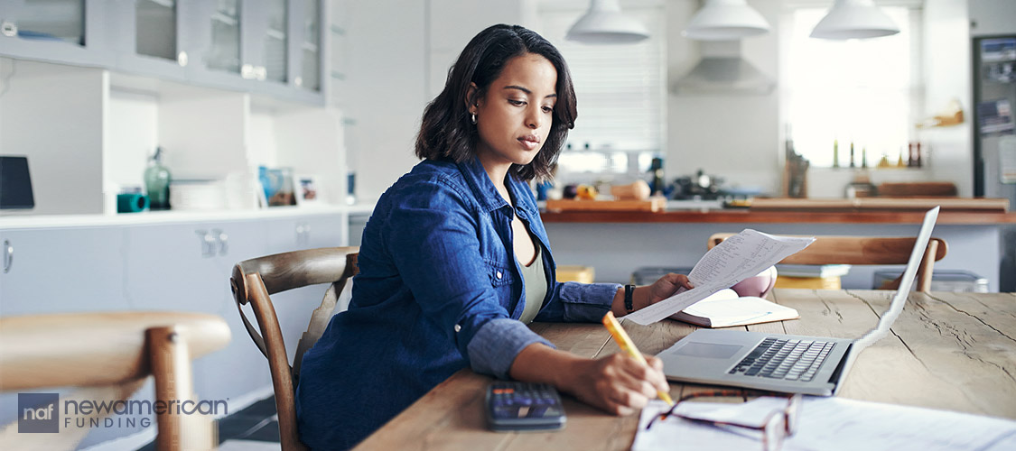 young woman going over paperwork in the living room