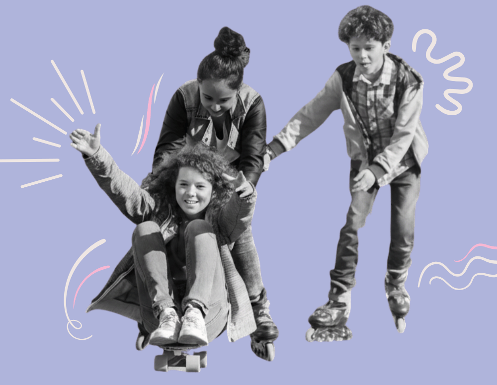 Two teens on roller blades push another teen who is sitting on a skateboard.