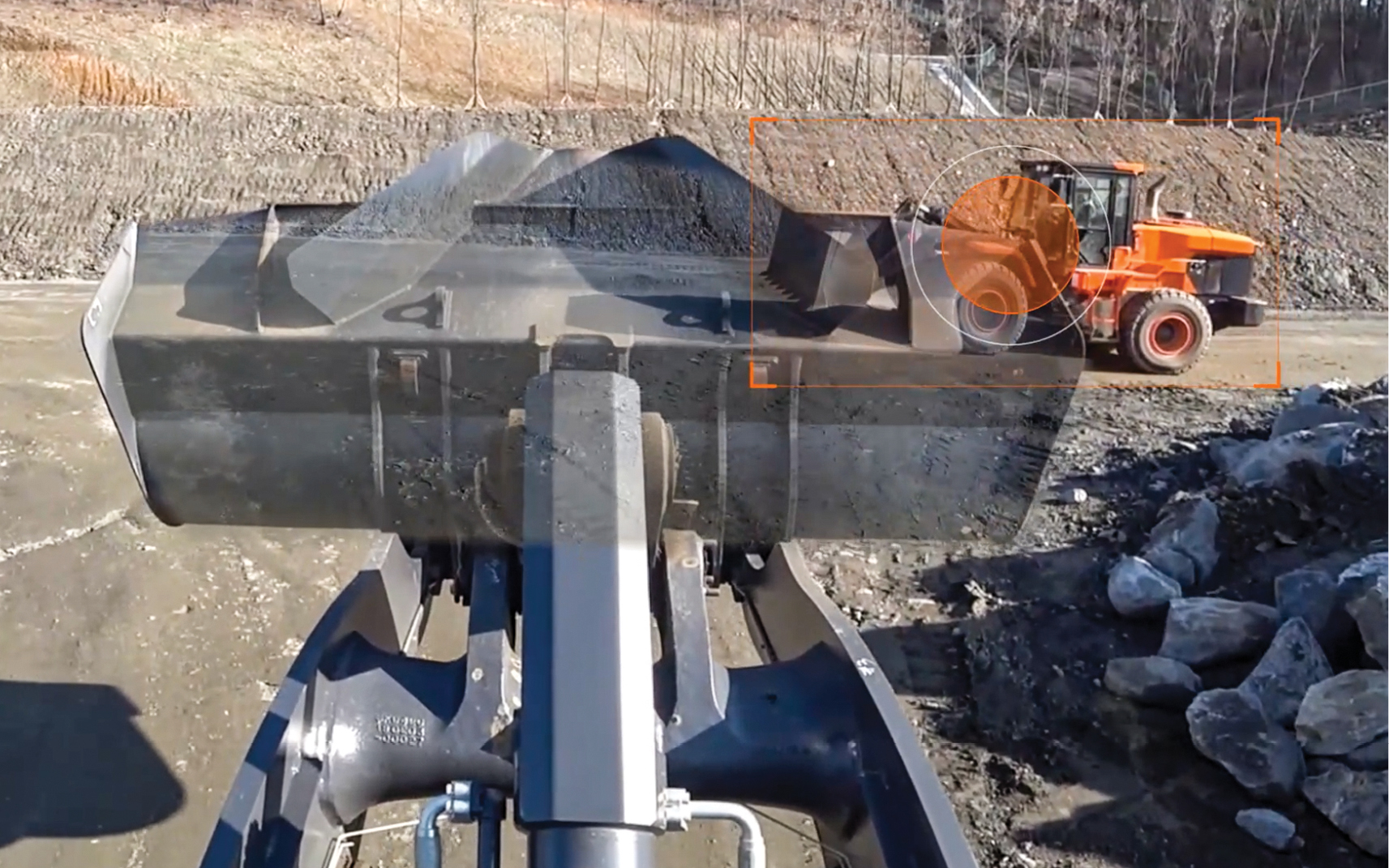 A wheel loader monitor utilizing the DEVELON transparent bucket technology shows another machine in its path.