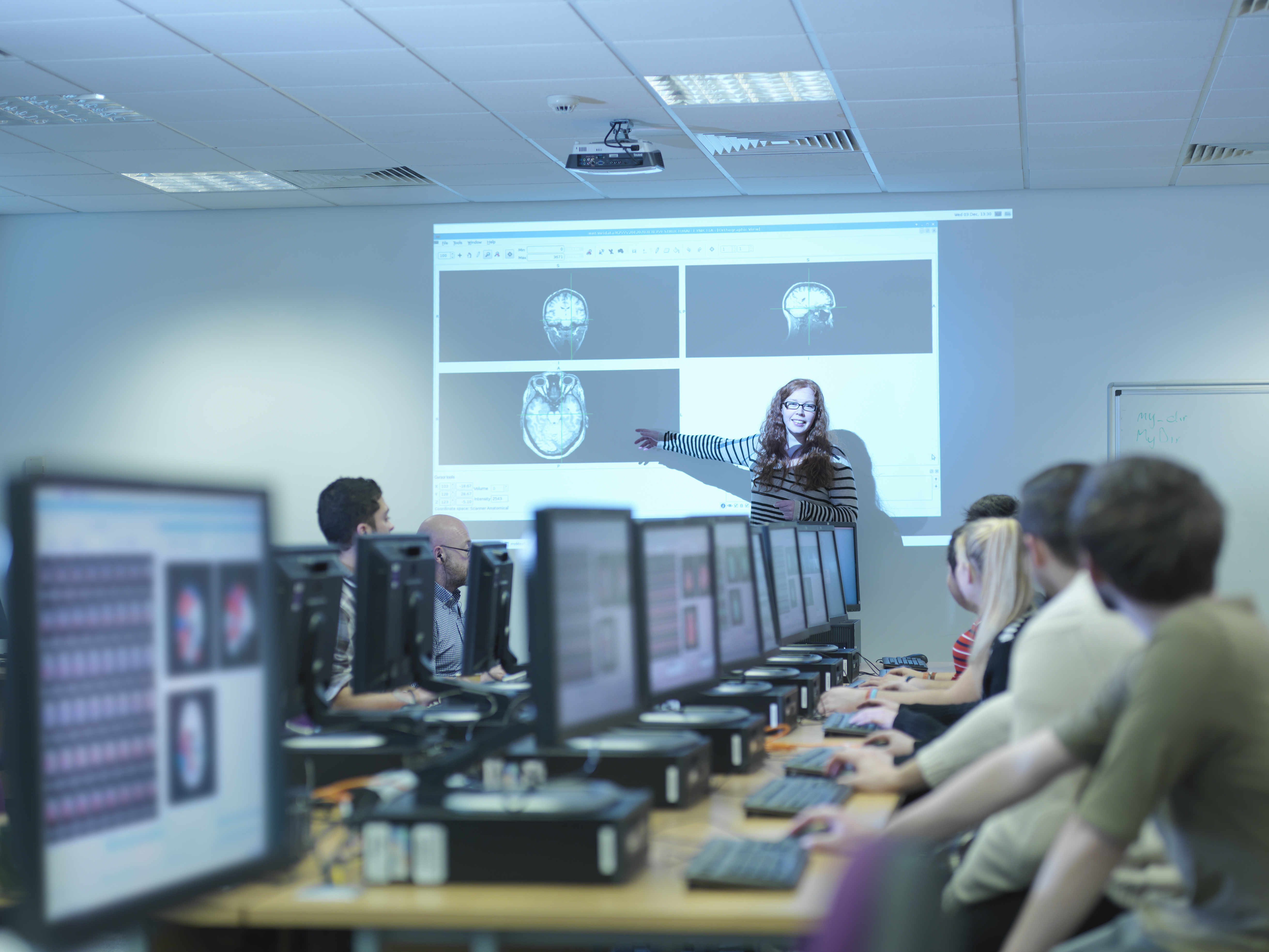 A student uses AV technology in the classroom to do a presentation with a 4k projector.