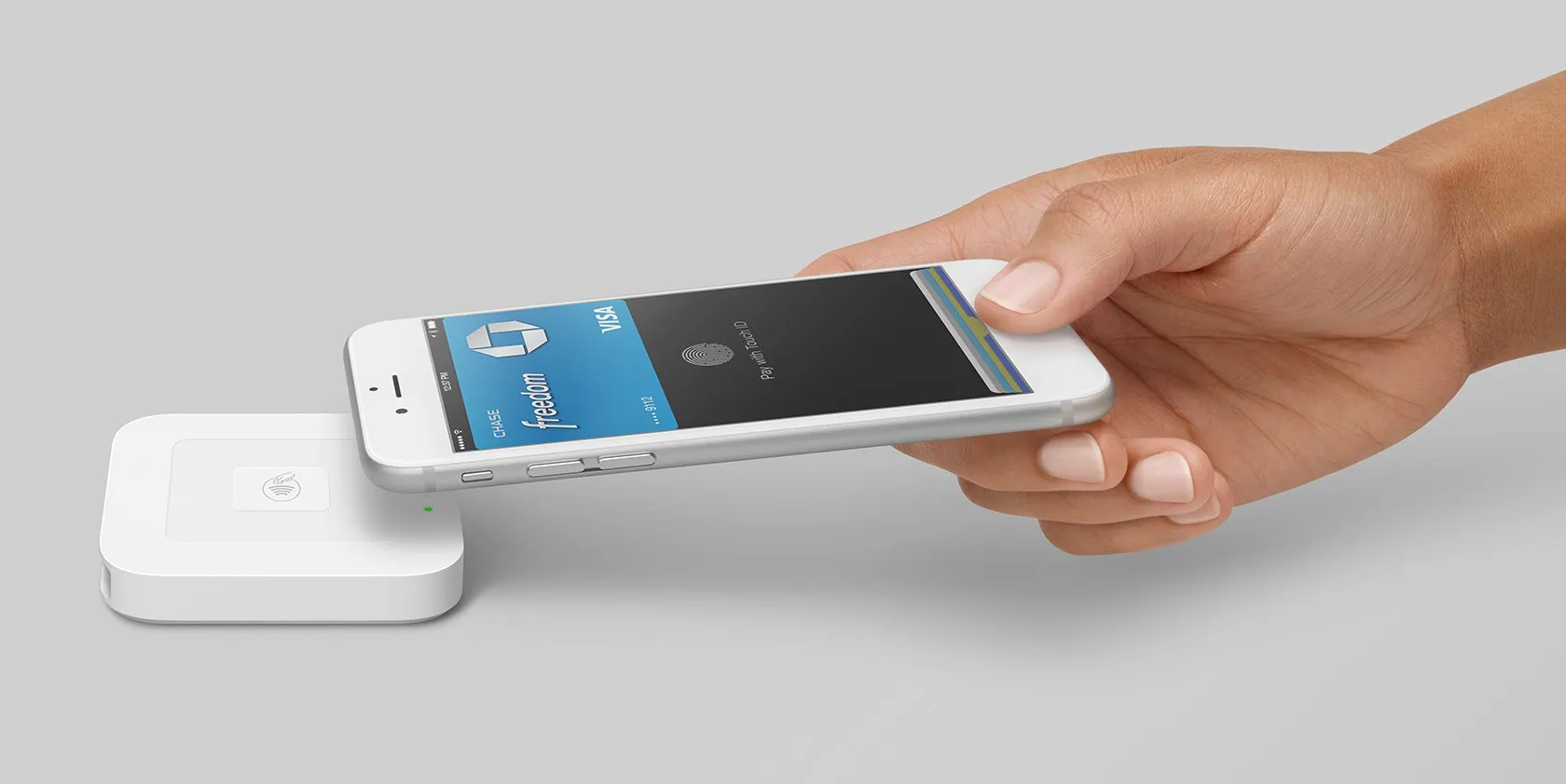 Image d’une main tenant un iPhone pour faire un paiement avec Apple Pay à côté d’un Square Reader sans contact et cartes à puce