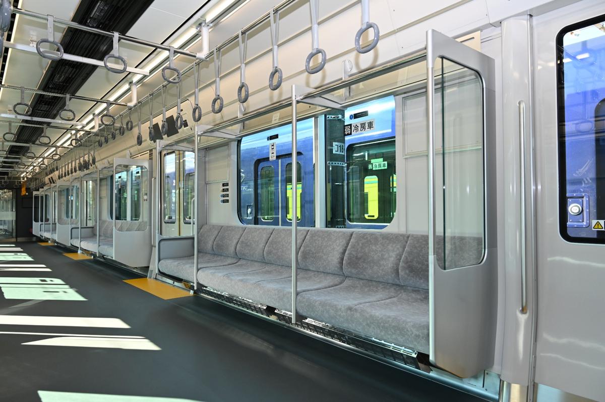 両内はグレーの柔らかなトーンに仕上げられている。ドア脇のパネルに安全性を確認したガラスを採用し、死角を作らないことでトラブルや事故防止にも寄与している。