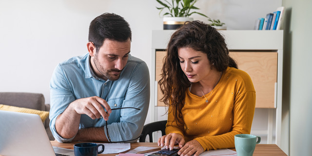 Young couple calculating their domestic bills at home stock photo